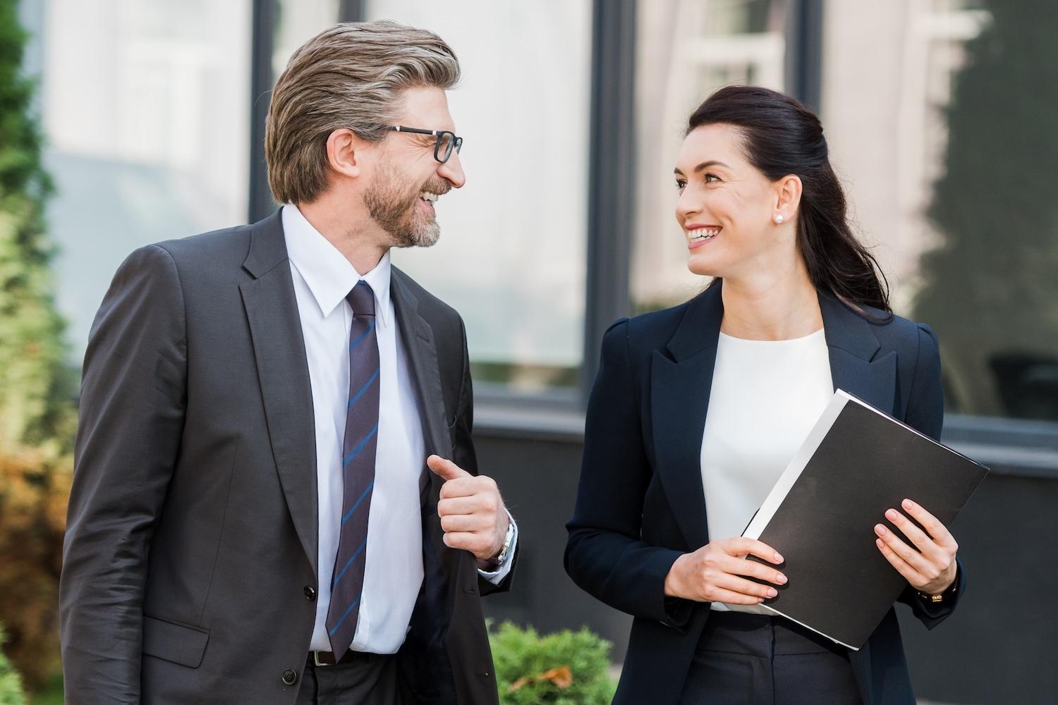 Two Public Sector professionals conversing outdoors near an office setting