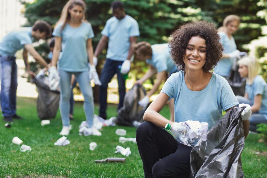 Group of volunteers with garbage bags cleaning park
