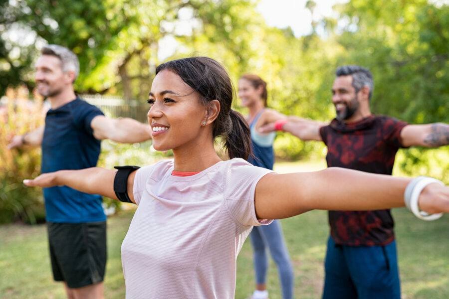 Mixed race woman exercising in park with mature friends